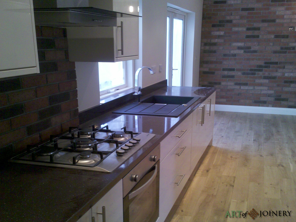 Dmitry’s fitted kitchen with cream cabinets, dark worktops and tiled splashback